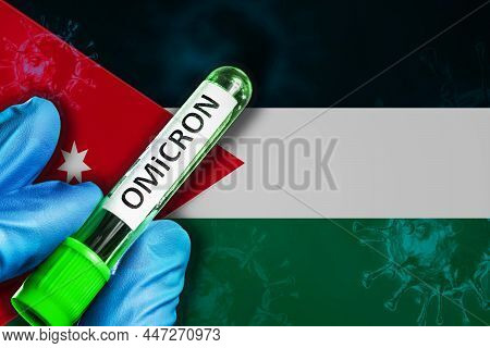 Jordan Outbreak Of Omicron Variant. A Hand In A Blue Rubber Glove Holds A Test Tube With Covid-19 Vi