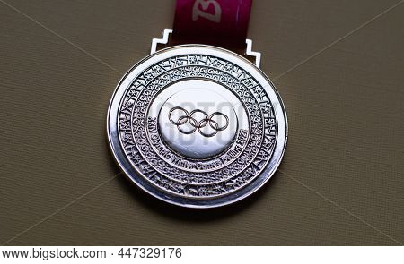 January 14, 2022, Beijing, China. Gold Medal Of The Xxiv Olympic Winter Games On A Yellow Background