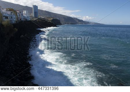 View On Colorful Houses And Black Lava Rocks In Small Village Punta Brava Near Puerto De La Cruz, Te