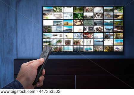 Video On Demand Service On Smart Tv. Person Sitting At Home Late At Night. Man Holding Mobile Phone 