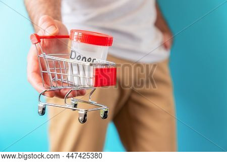 A Man Is Holding A Small Cart With A Jar Of Sperm In His Hand For Analysis. Close-up. The Concept Of