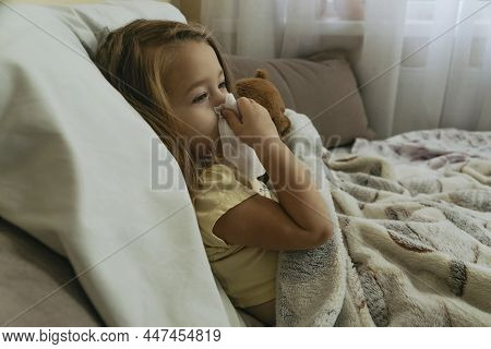 Portrait Of Little Girl Blowing Her Nose.
