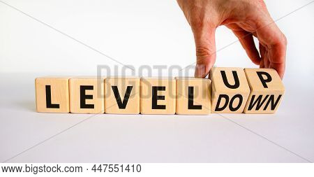 Level Up Or Down Symbol. Businessman Turns Cubes And Changes Concept Words Level Down To Level Up. B