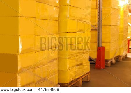 Warehouse With Stacks Of Boxes On Wooden Pallets. Wholesaling
