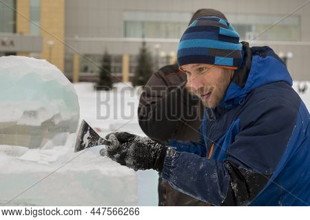 Portrait Of A Sculptor In A Blue Winter Suit With A Chisel In His Hands At Work