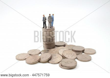 A Group Of Mini People On Coin, Business Concep