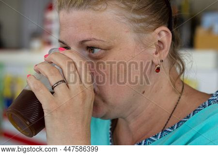 A Young Woman Thirstily Drinks Juice From A Glass