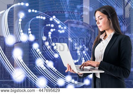 Attractive Young European Businessman Using Laptop With Creative Circular Light On Blurry City Backg