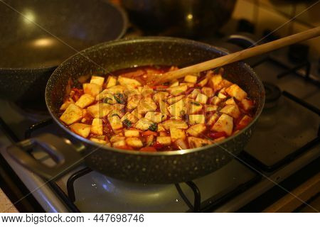 Close-up Of Cooking Celery Dish In The Pot. The Cooked Food Is Mixed With A Wooden Spoon.