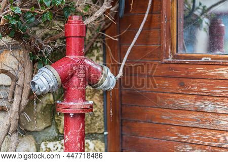 Close-up - Overhead Red Pressurized Fire Hydrant Against Wooden House