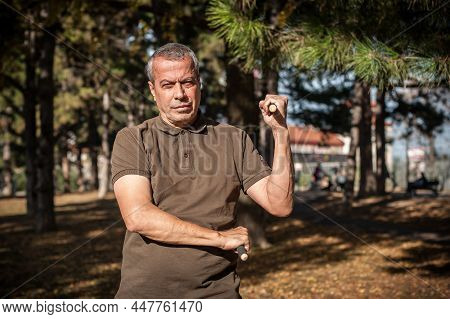 Escrima And Kapap Instructor Demonstrates Sticks Fighting Techniques In Park