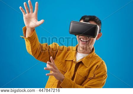 Portrait Of Smiling Young Man Enjoying Augmanted Reality And Playing Videogame