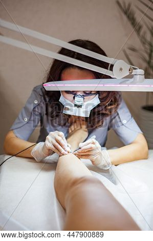 A Female Cosmetologist Performs The Procedure Of Permanent Removal Of Unwanted Hair On The Client's 