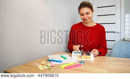 Young Woman Creating Feng Shui Wish Map Using Scissors. Blond Cut Out Photos For Visualization Of Dr