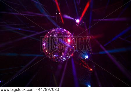 Mirrored Disco Ball And Bright Beams At The Night Party. Party Attribute Reflects Lazer Lights. Abst