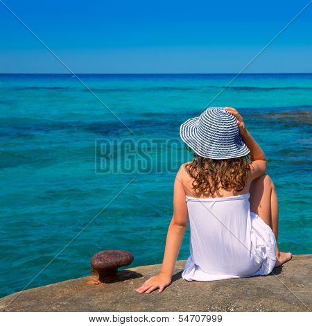 Girl looking at beach in Formentera turquoise Mediterranean sea background