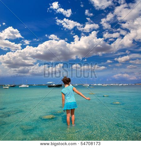 Kid girl walking at formetera in Estany des Peix lake rear view