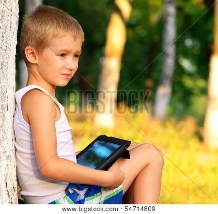 Boy Child Playing With Tablet Pc Outdoor With Forest On Background Game Dependence And New Technolog