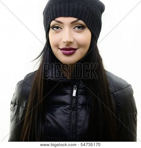 portrait of beautiful young woman in black hat and jacket, studio shot over white