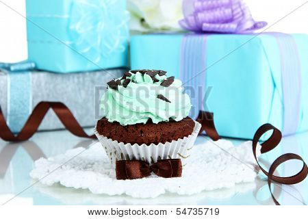 Tasty cupcake with gifts close up