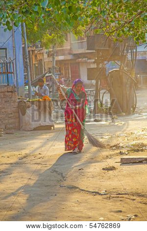 Indian Women Of Fourt Class In Brightly Colored Clothing Cleans The Street