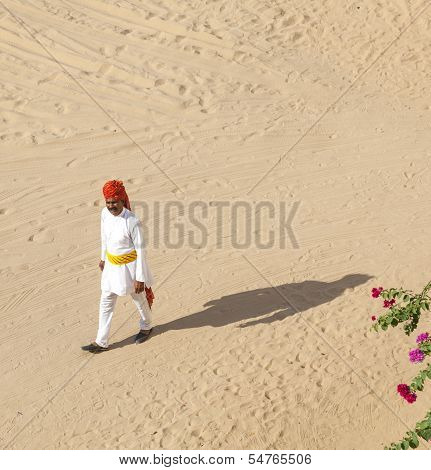 Rajasthani Man With Bright Red Turban And Bushy Mustache Walks Over The Sandy Area In The Desert Hot