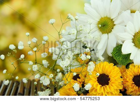 Beautiful flowers on table on bright background