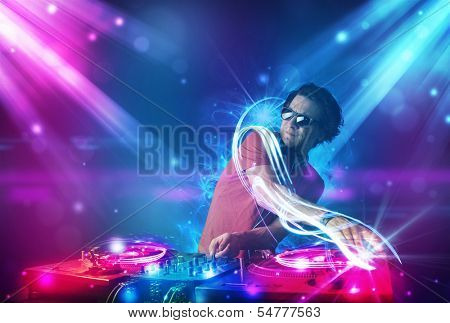 Young energetic Dj mixing music with powerful light effects