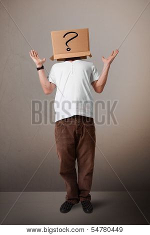 Young man standing and gesturing with a cardboard box on his head with question mark