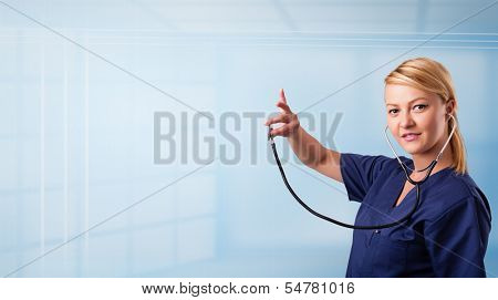 Pretty young nurse in hospital listening to empty copy space with sthetoscope