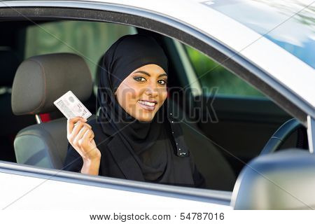 cheerful muslim woman showing a driving license she just got