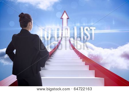 The word to do list and businesswoman with hands on hips against red steps arrow pointing up against sky