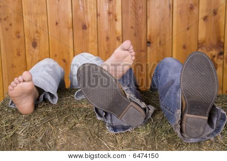 Füße und Schuhe auf Heuballen
