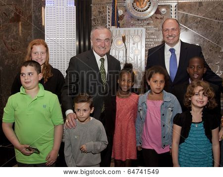 NEW YORK-APR 21, 2014: Police Commissioner William Bratton and children of honored NYPD officers at ceremony to light the Empire State Building in blue and purple in honor of Police Memorial Week.