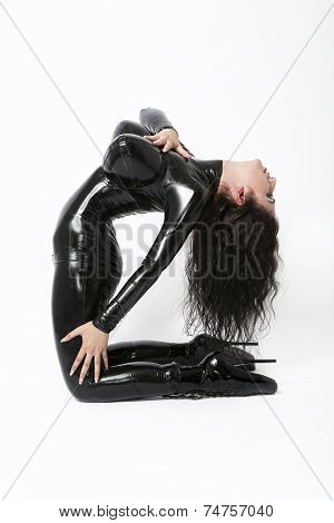 Sexy flexible brunette in black latex and boots whit high heels arching back