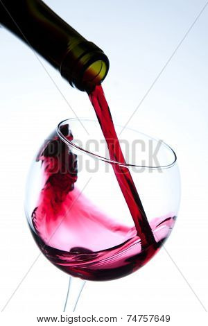 Red wine pouring into wine glass