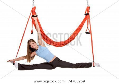 Young woman making antigravity yoga exercises in stretching twine