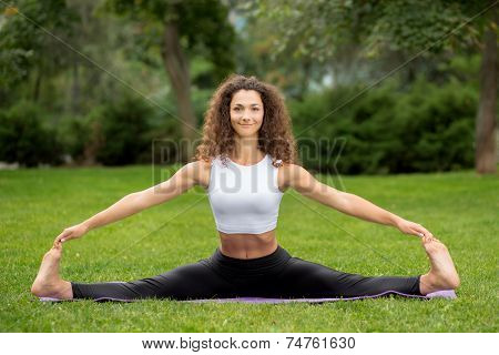 Smiling pretty woman doing yoga exercises