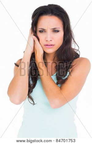 Pretty brunette getting an earache on white background