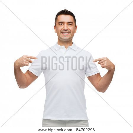 happiness, advertisement, fashion, gesture and people concept - smiling man in t-shirt pointing fingers on himself