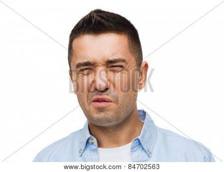 emotions, facial expression and people concept - man wrying of unpleasant smell