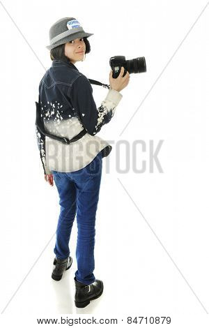 A pretty young school photographer, looking back at the viewer as she's off to get some photos for her yearbook.  On a white background.