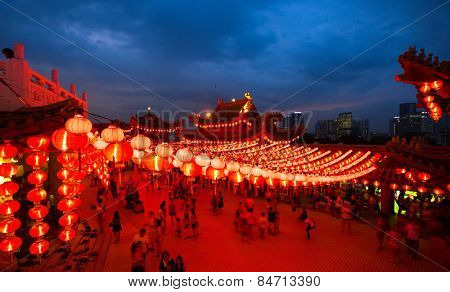 KUALA LUMPUR, MALAYSIA - FEBRUARY 23, 2015: Tourists visit the scenic Thean Hou Temple at night with hundreds of lanterns hung across the courtyard celebrating the lunar Chinese New Year.