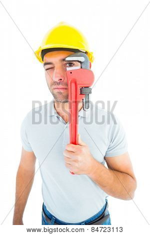 Manual worker looking through monkey wrench on white background
