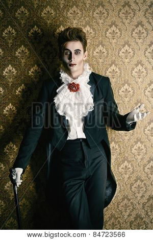 Portrait of a handsome male vampire over vintage background. Halloween. Dracula costume.