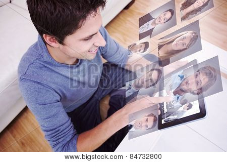 Overhead view of man using digital tablet in living room against business people disscussing a budget plan
