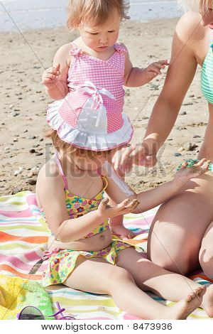 Sladká holčička pomocí Suncream na pláži