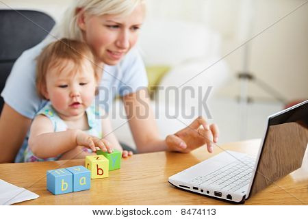 Positivo famiglia utilizzando portatile e giocare con i giocattoli