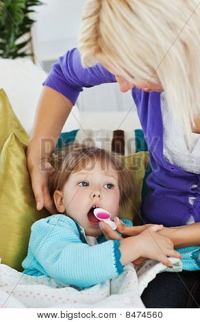 Sick Little Girl Getting sciroppo da sua madre premurosa