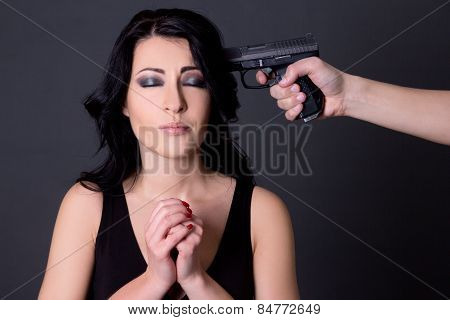 Violence - Young Beautiful Woman Hostage And Male Hand With Gun Over Grey